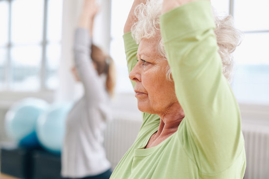 Senior woman practicing yoga at gym